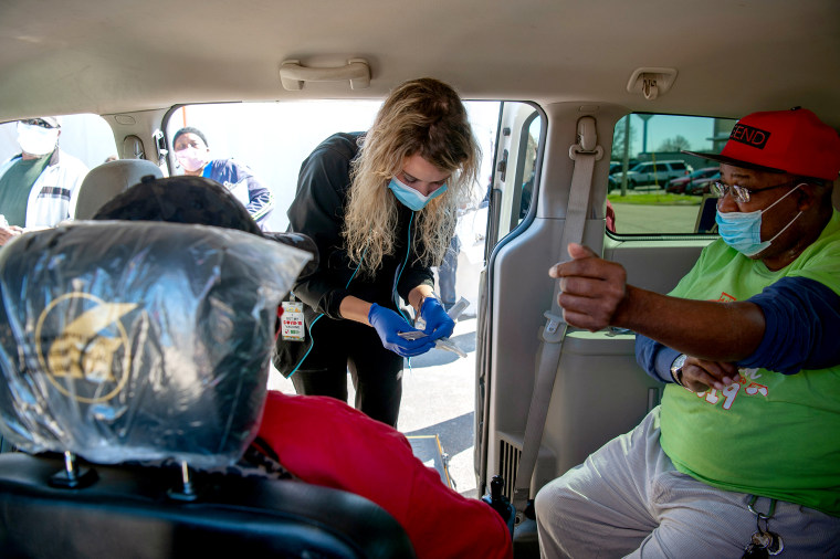 A healthcare worker arrives to administer a dose of the Moderna Covid-19 vaccine to people in a Vaccination Transportation Initiative sponsored van outside a medical clinic in Ruleville, Miss., on March 4, 2021.