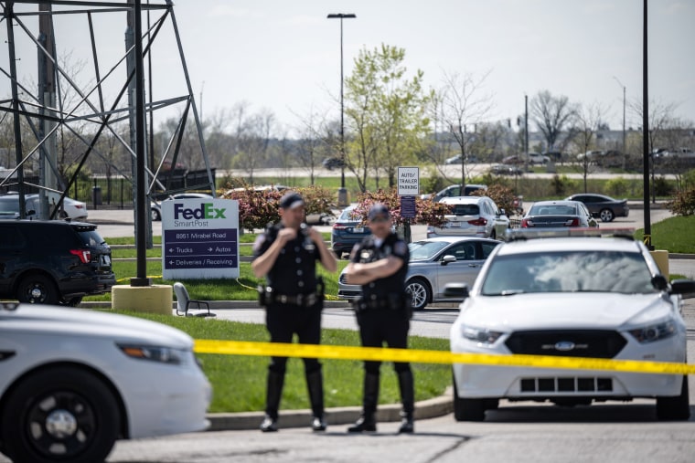 Image: Police officers stand behind caution tape near a crime scene on April 16, 2021 in Indianapolis.