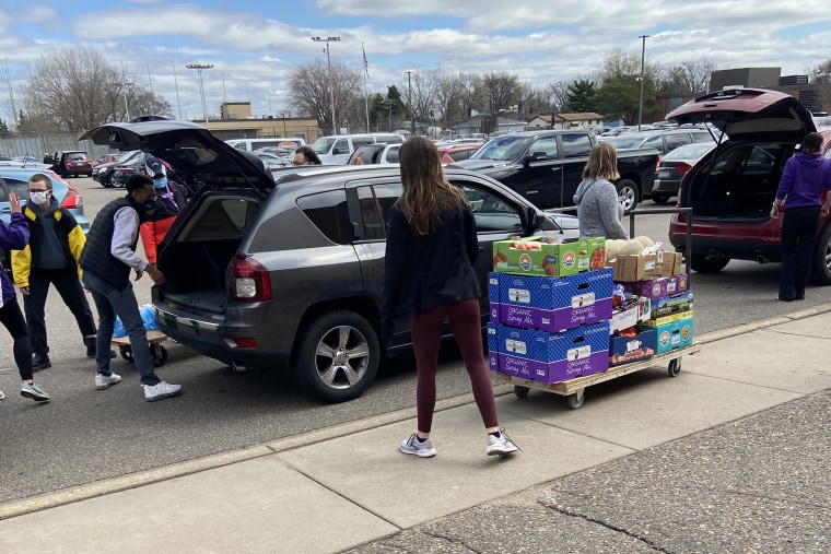 Image: Volunteers load bags of groceries for needy families