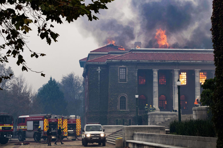 Firefighters work to extinguish a fire in the University of Cape Town's library after a forest fire came down the foothills of Table Mountain in Cape Town, South Africa, on April 18, 2021.