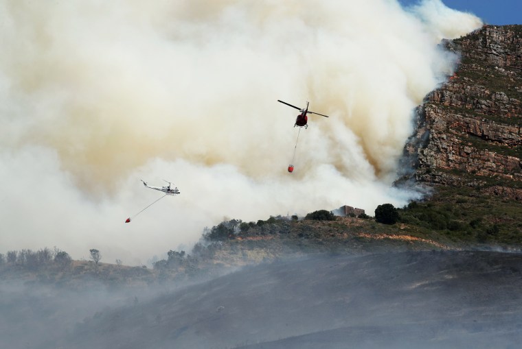 Helicopters battle to contain a bushfire that broke out on the slopes of Table Mountain in Cape Town, South Africa, on April 18, 2021.