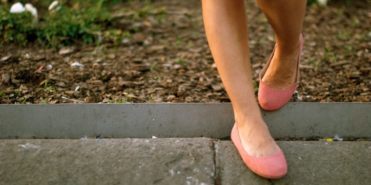 Spain, Catalonia, Barcelona, View of woman's legs in ballerina shoe