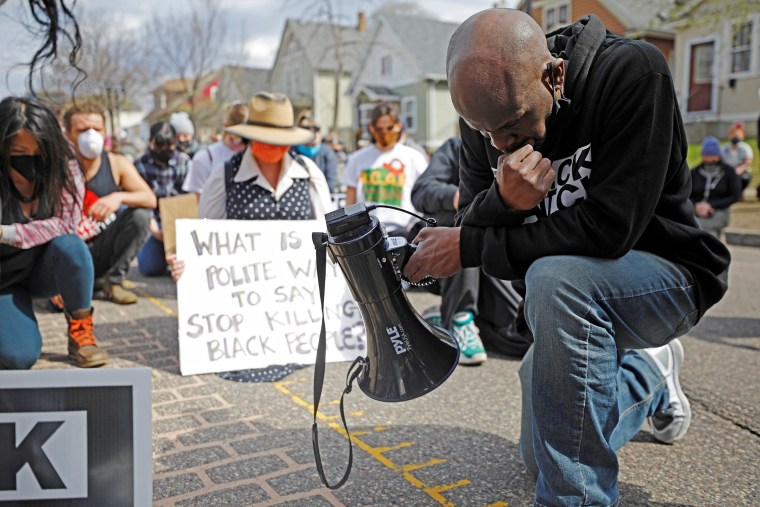 Image: Demonstrators kneel for a moment of silence during a march from the Governor's Residence the weekend before closing arguments in the Derek Chauvin trial in St. Paul, Minn.