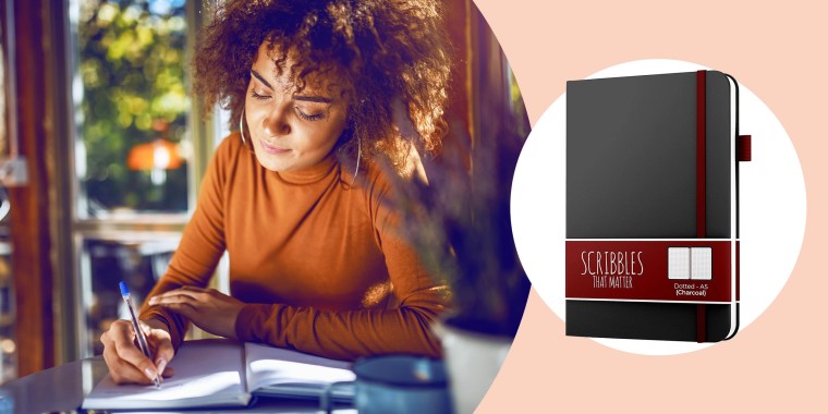 Illustration of a Woman writing in her journal at a desk and the A5 Dotted Journal by Scribbles That Matter  in black. See the best bullet journal notebooks and planners of 2021. Learn how to bullet journal and how it can help organize your life and impro