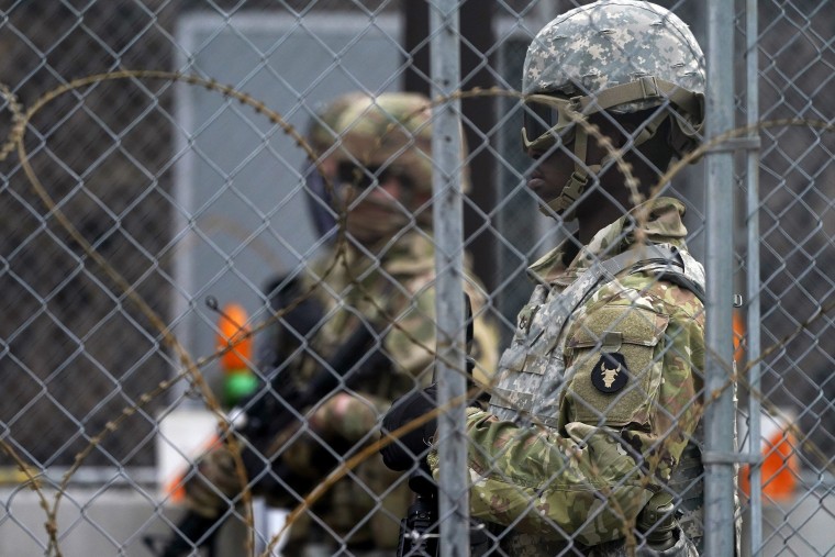 Image: National Guard members are seen through fencing and wire near the Minneapolis Police 3rd Precinct in Minneapolis