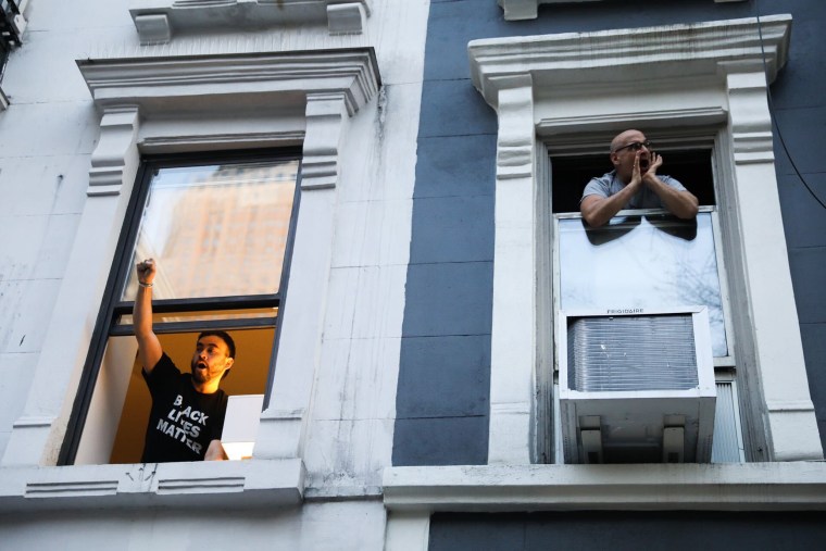 People cheer from their apartments as protesters walk by in New York on April 20, 2021, following the conviction of former Minneapolis police officer Derek Chauvin for the murder of George Floyd. Julius Constantine Motal / NBC News