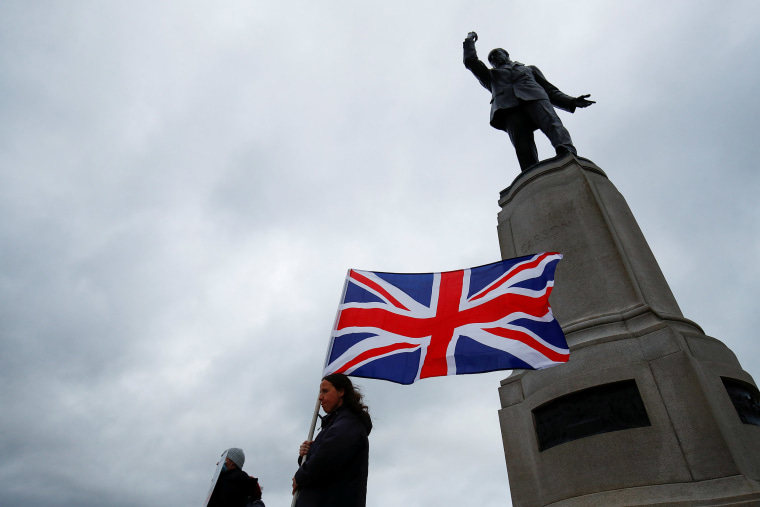 Image: A person holds a British Union Jack flag, as pro-British unionists demonstrate near Parliament buildings, amid nightly outbreaks of street violence in the region that have left dozens of police officers injured, in Belfast, Northern Ireland