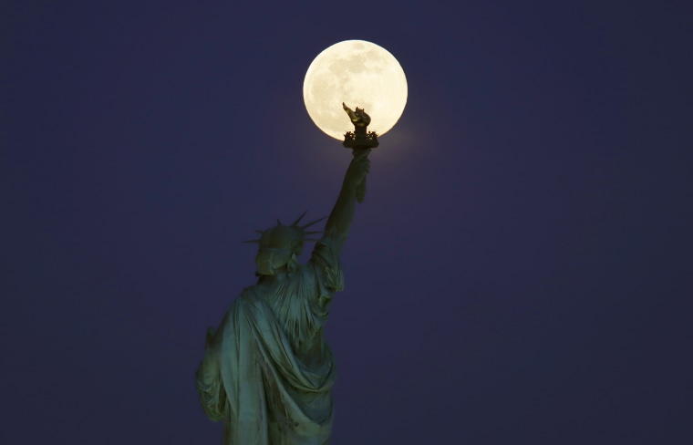 Super Pink Moon Rises Above the Statue of Liberty in New York City