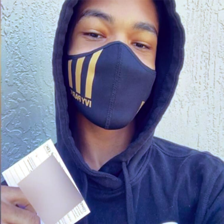 Malachi White, a student in Jacksonville, Florida, shows off his vaccination card. He's part of a group of teens from the I'm a Star Foundation who participated in a public service campaign to get the word out about vaccines among young people. 