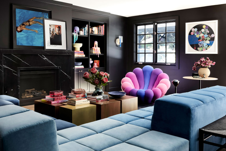 Cyrus' sitting room features black walls, a funky chair and fun pops of color.