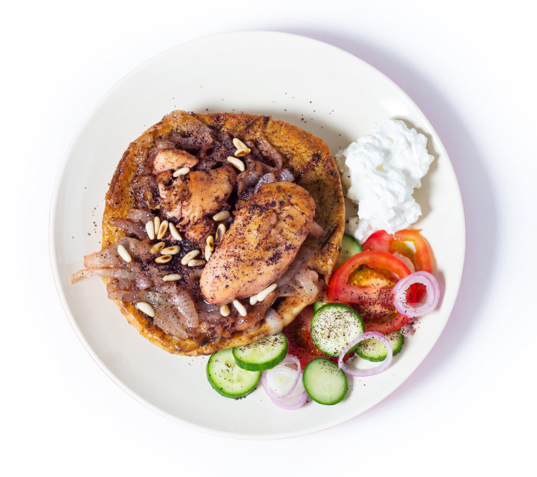 Musakhan, traditional Palestinian sumac chicken, on a plate with a salad and yoghurt, from above