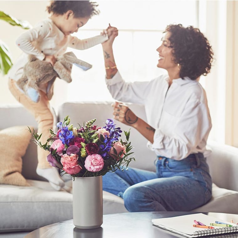 Mother Playing with her son, with flowers in front of her