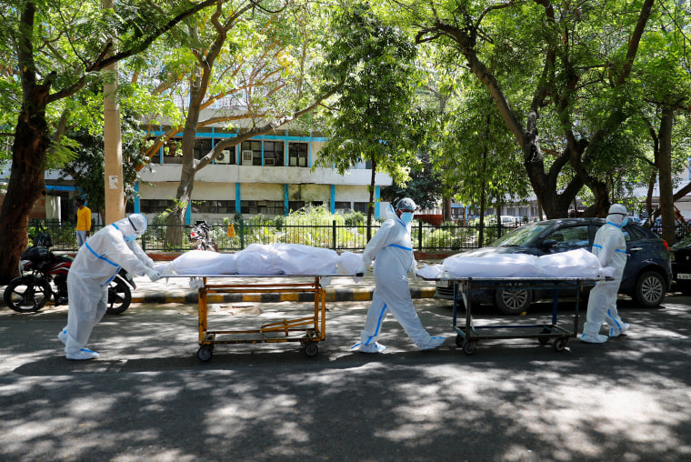 Image: Health workers carry bodies of people who were suffering from Covid-19 outside the Guru Teg Bahadur hospital in New Delhi,