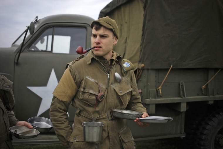 A World War II re-enactor waits in line to eat lunch.