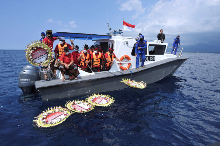 Image: People throw flowers and petals with names of the sunken KRI Nanggala-402 submarine crew members during a prayer at the sea near Labuhan Lalang, Indonesia on Monday.