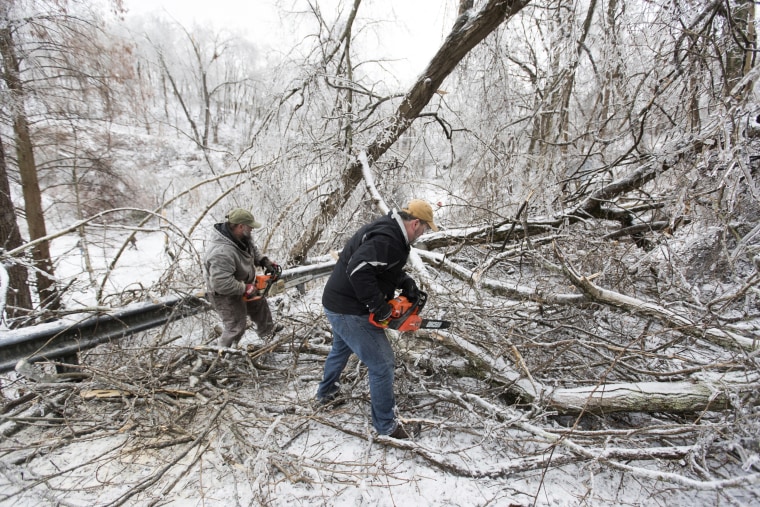Area residents work to clear downed trees along Honeysuckle Lane on Feb. 16, 2021, in Huntington, W.Va.,