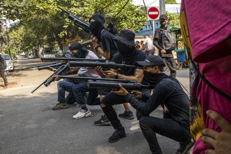 Image: Anti-coup protesters line in formation with homemade air rifles during a demonstration against the military coup in Yangon, Myanmar
