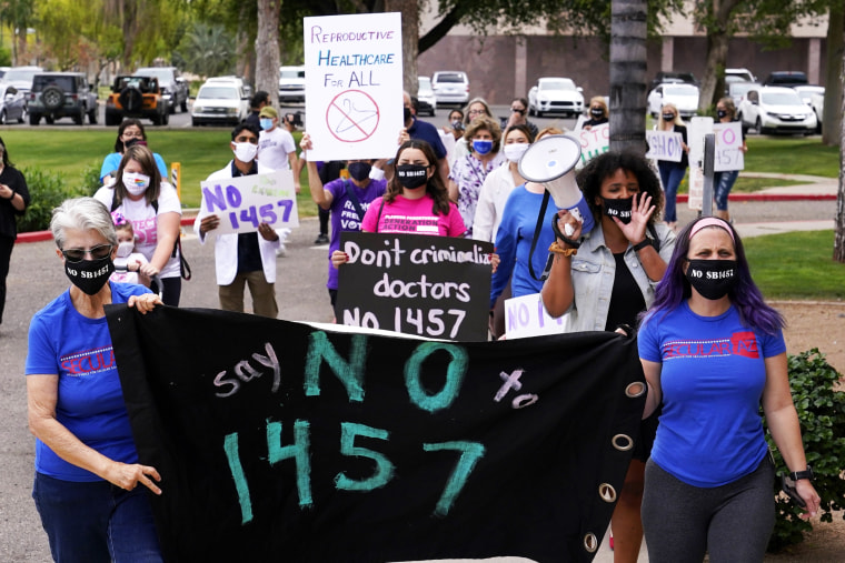 A number of Arizona reproductive rights groups march to deliver a petition to Gov. Doug Ducey to veto SB 1457, the latest abortion bill passed by the state legislature, at the capitol on April 26, 2021, in Phoenix.