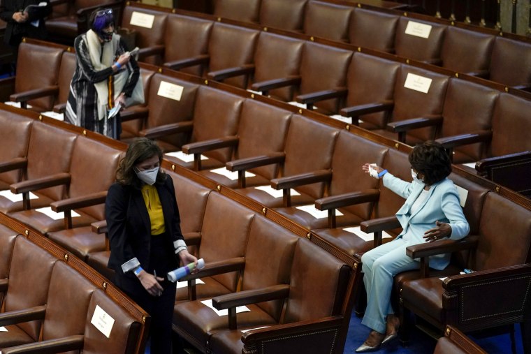 Image: Rep. Maxine Waters, D-Calif., gestures to Rep. Rosa DeLauro, D-Conn., as they arrive for President Joe Biden's joint address to Congress at the Capitol on April 28, 2021.