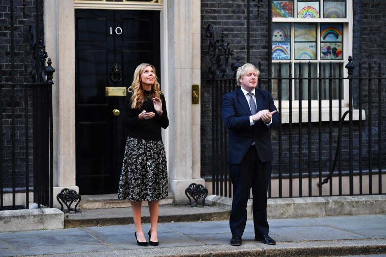 Image: Johnson and his fiancée Carrie Symonds applaud key workers in May last year