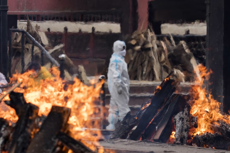 Image: A man performs the last rites to a relative at a New Delhi crematorium last week