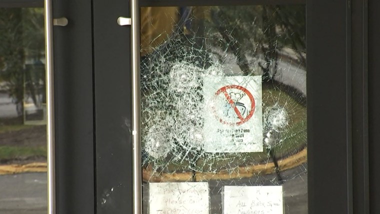 The door to a synagogue is damaged after a person through a rock at it in the Bronx borough of New York.