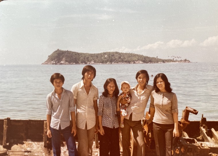 My mom Lynn (center) with my dad Huy, holding me, and other family members in Malaysia, 1979.