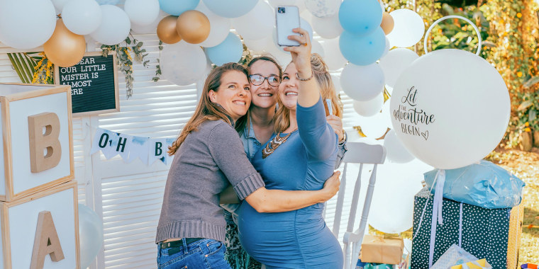 Three family members hugging at a baby shower