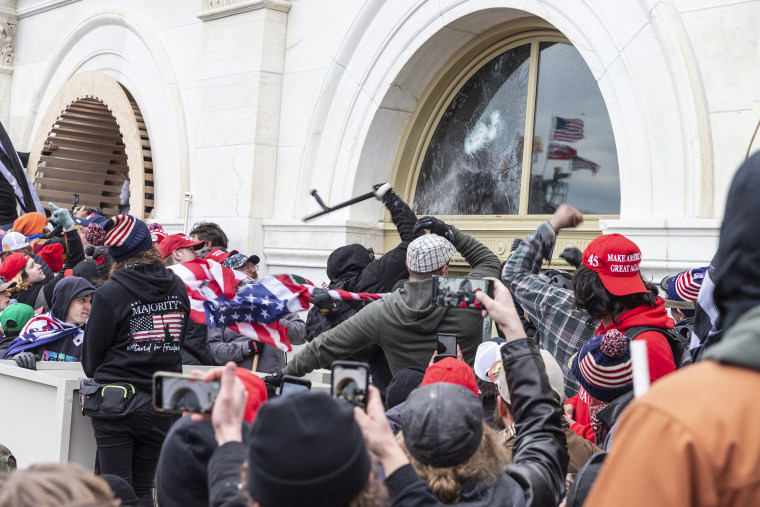 Pro-Trump protesters break windows of the Capitol building.