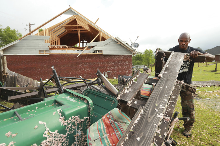 Alfred Lee cleans up and sorts through the debris in his backyard on May 3, 2021 after a tornado hit the area late Sunday night in Tupelo, Miss.