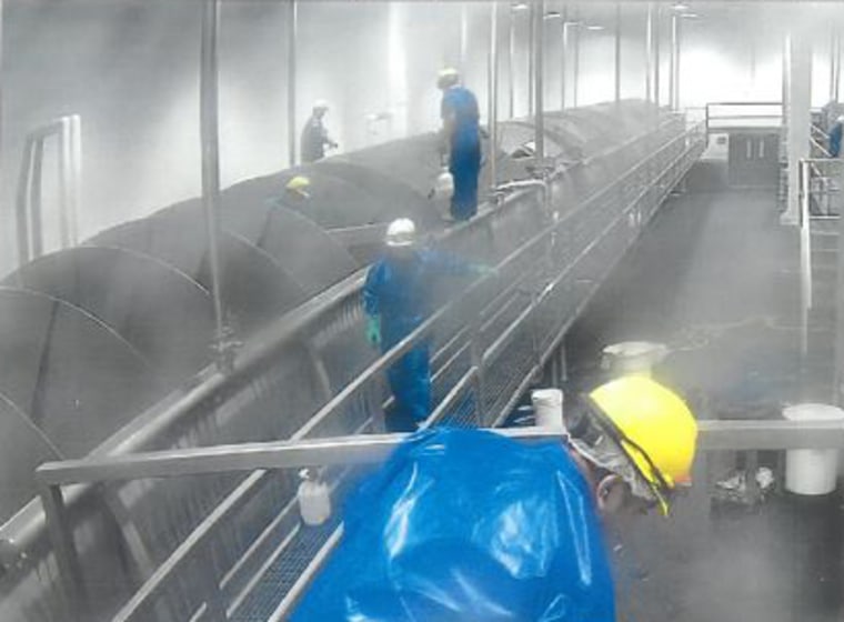 Image: Workers climbing into the machine to clean it while operating