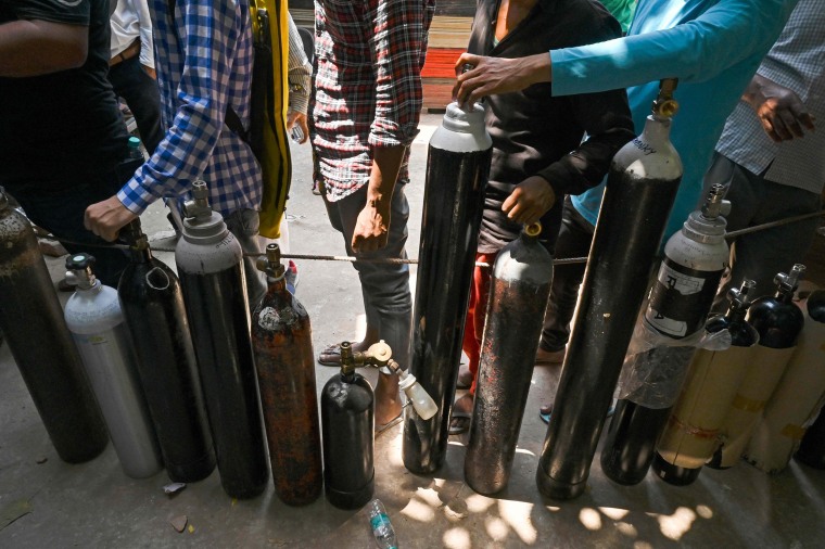 Image: People wait in a line to refill oxygen cylinders for Covid-19 patients at a refilling center in New Delhi