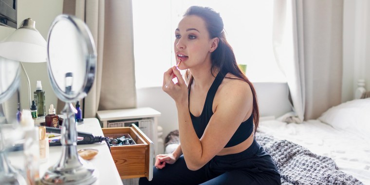Woman looking in the mirror putting on makeup. Shop the best lighted makeup mirrors of 2021. These highly rated lighted makeup mirrors from RIKI and Fenair are available at Walmart, Amazon, Ulta and more.
