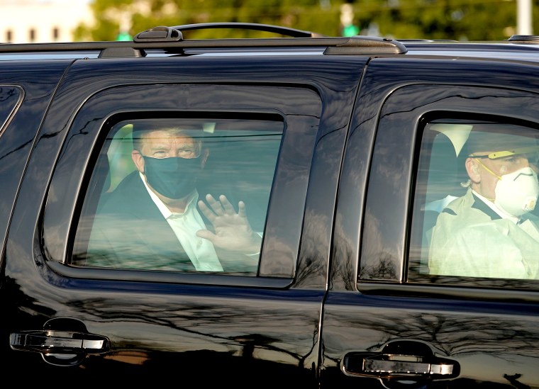 Image: President Trump waves from the back of a car in a motorcade outside of Walter Reed Medical Center in Bethesda, Md., on Oct. 4, 2020.
