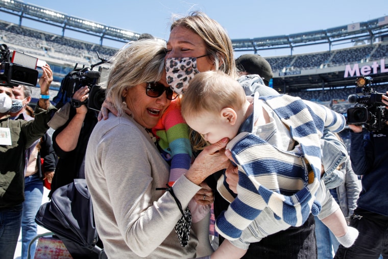 Image: Peggy Broda meets her grandchild in person for the first time during a mass reunion event at MetLife Stadium in East Rutherford, New Jersey
