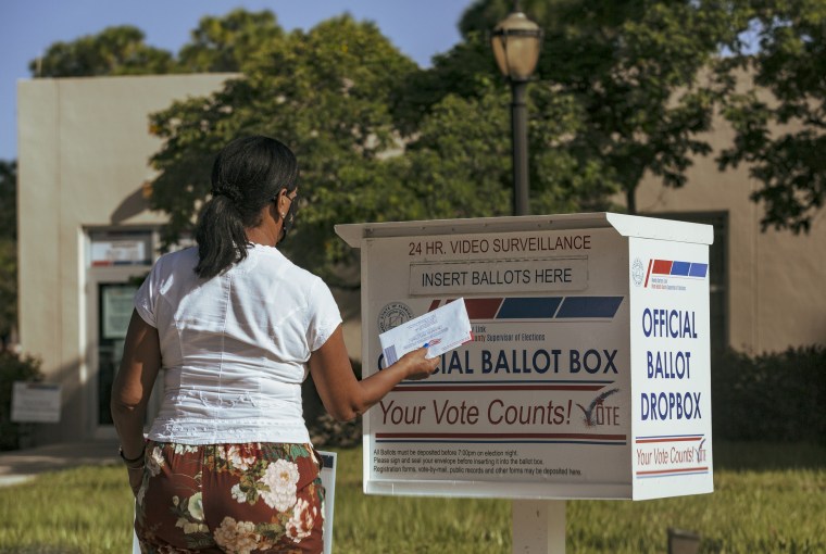 IMage: A woman puts a ballot in a drop box in West Palm Beach, Fla., on Nov. 1, 2020.