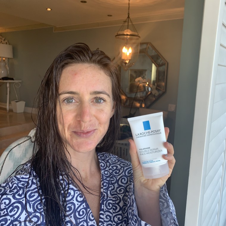 holding the bottle of La Roche-Posay Double Repair Moisturizer while on safari in Africa