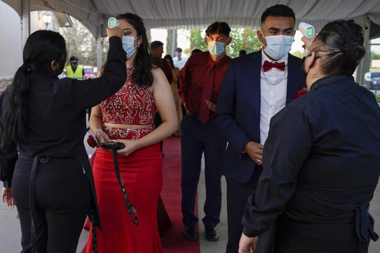 Grace Gardens Event Center employees check temperatures of young people attending prom at the Grace Gardens Event Center in El Paso, Texas on Friday, May 7, 2021. Around 2,000 attended the outdoor event at the private venue after local school districts announced they would not host proms this year.