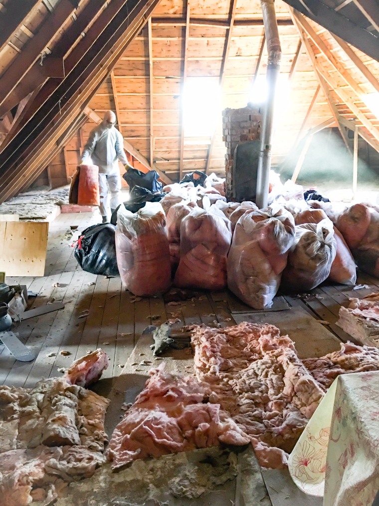 Image of a messy attic with trash bags.