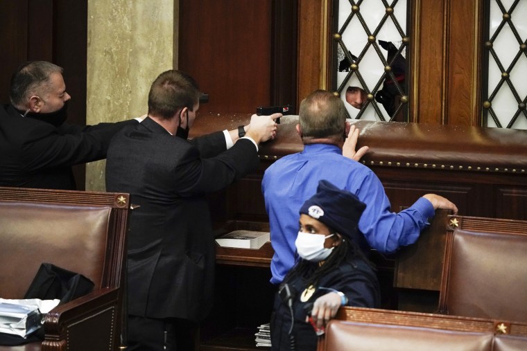 Image: Police with guns drawn watch as protesters try to break into the House Chamber on Jan. 6, 2021.