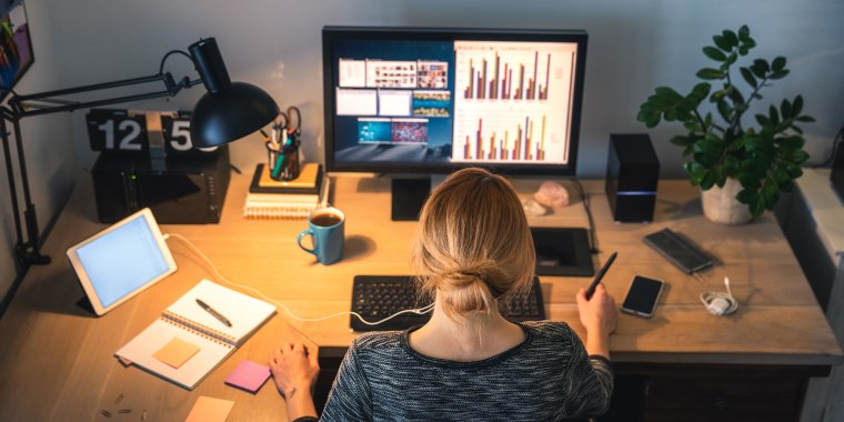 Woman working on computer desktop in her home office