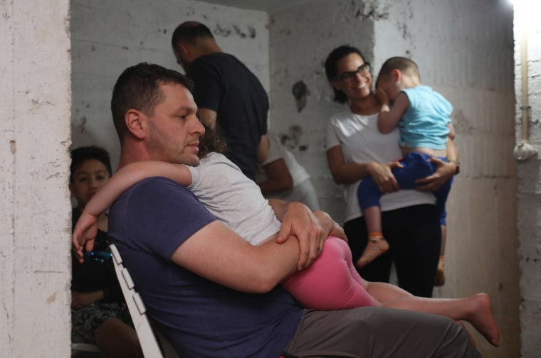 Image: People take shelter in the basement of a building in the Israeli coastal city of Tel Aviv in the early hours of May 13, 2021, after rockets were launched towards Israel from the Gaza Strip.