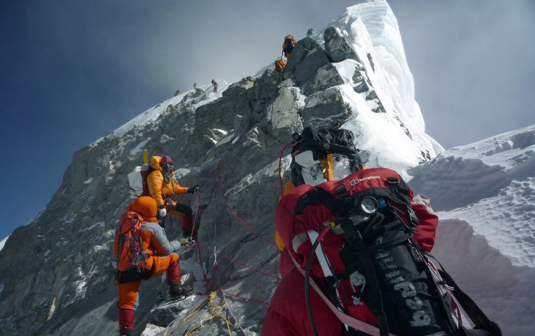 Image: Unidentified mountaineers walk past the Hillary Step while pushing for the summit of Mount Everest as they climb the south face from Nepal.