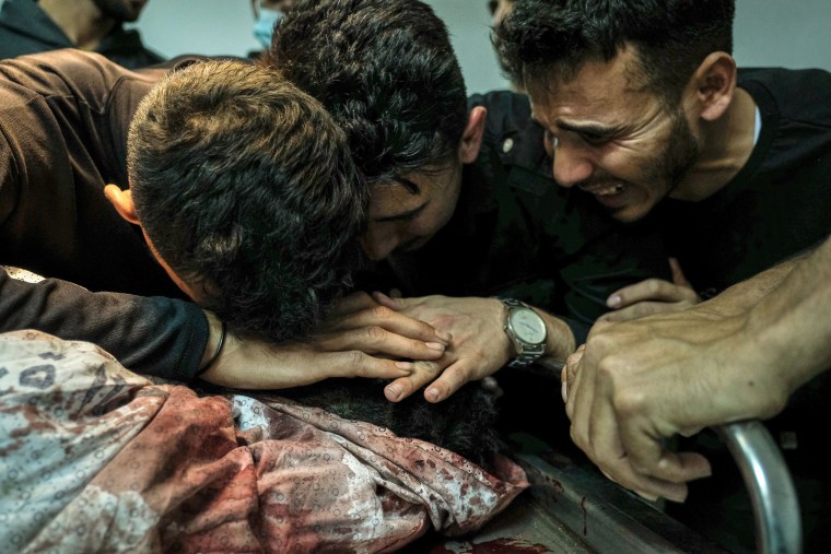 Image: Relatives of Palestinian Izz al-Deen Helles during his bid farewell at Al-Shifa Hospital
