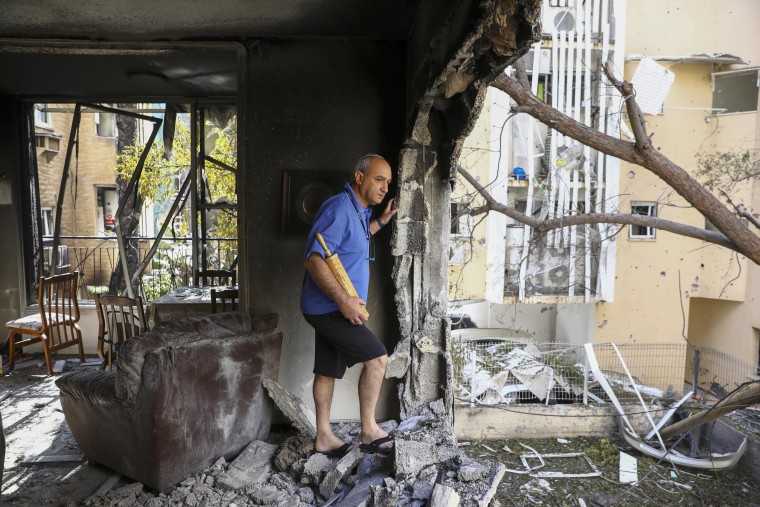 Image: A member of Sror family inspect the rocket damage to their apartment in Petah Tikva, Israel, on Thursday.