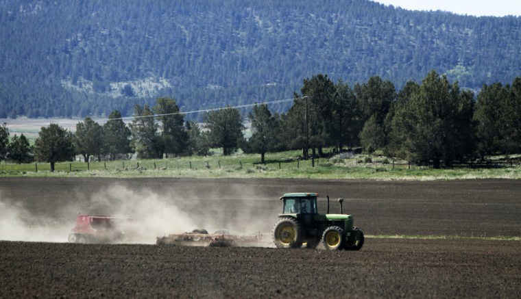 Image: A tractor works a parcel of farm land in the Klamath Basin near Klamath Falls, Ore., on April 8, 2015.