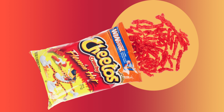 Opened bag of Cheetos Crunchy Flamin? Hot snacks with some pouring out onto white background