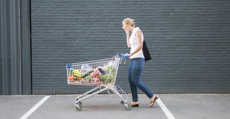 Netherlands, Tilburg, Woman walking with shopping cart