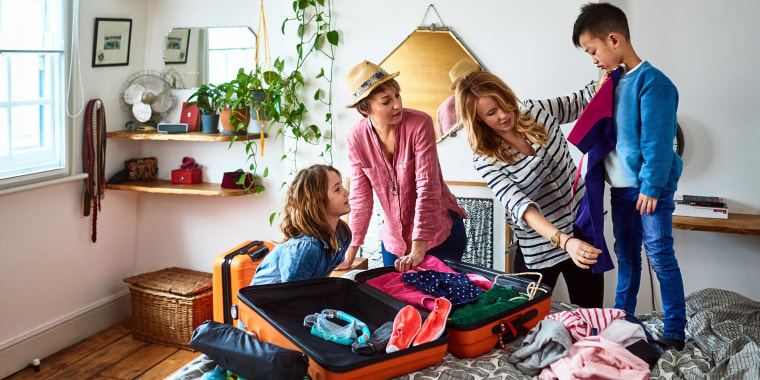 Couple packing suitcases for vacation with two children