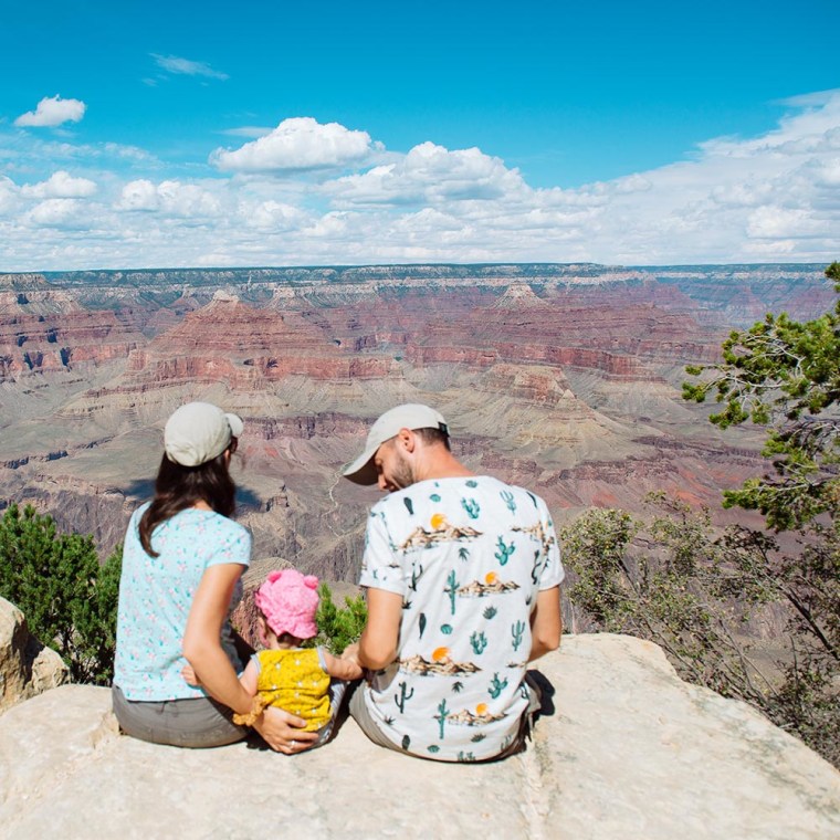 Family sitting on the edge of cliff in Grand Canyon National Park